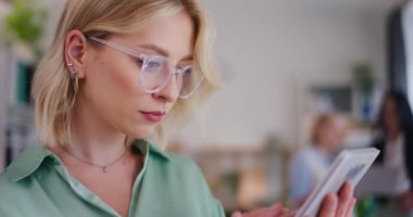 Bir iş kadını dijital tablet kullanır, internette gezinir ve düşüncelerde kaybolur..