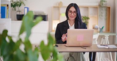 Bir kadın, bir dizüstü bilgisayarla online görüşme yapıyor..