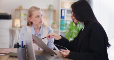 İki konsantre olmuş, kendine güvenen kadın ofis çalışanı ofiste tartışıyor..