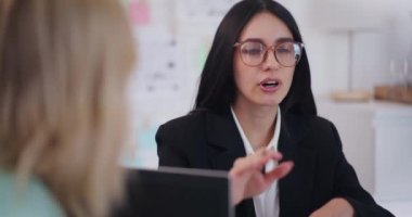 Kendine güvenen bir iş kadını, bir iş toplantısı sırasında iş stratejileri ve şirket geliştirme fikirlerini tartışıyor.