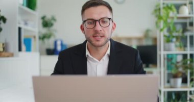 Bir adam çalışanlarıyla video konferansı düzenliyor..