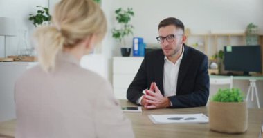 Emlakçı bir emlak bürosu toplantısında bir müşteriyle tartışıyor..