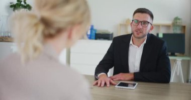 Ofisteki bir iş toplantısında bir emlakçı bir müşteriyle konuşuyor..