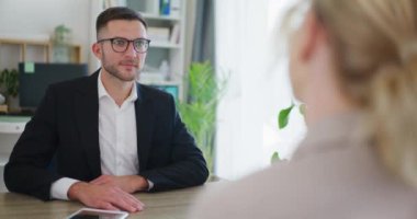 Gülümseyen emlakçı, verimli pazarlıklar sırasında müşteriyle tokalaşıyor..