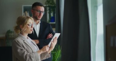 Tatmin olmuş iş adamları dijital tablette bir projeyi tartışıyor.