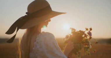 Günbatımına karşı kaygısız bir kadın görüntüsü.