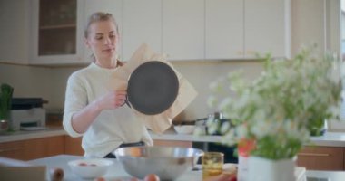 Bir kadın kek hazırlamak için fırın tepsisinin etrafında fazla kağıt buduyor..