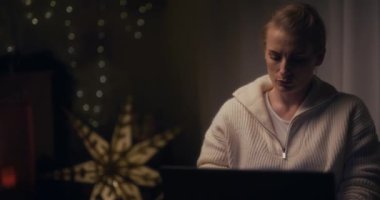 Bir kadın dizüstü bilgisayarını geceleri sinirli bir şekilde kapatıyor, hayal kırıklığına uğramış ve zor müşterilerle başa çıkamıyor..