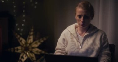 Bir kadın gergin bir şekilde gece geç saatlerde laptopunu kapatıyor, iş gecikmelerinden bunalmış bir şekilde..