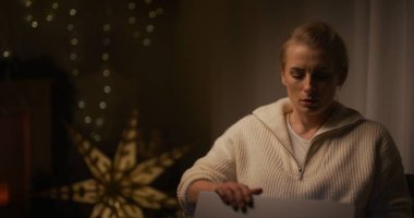 Bir kadın gergin bir şekilde gece geç saatlerde laptopunu kapatıyor, iş gecikmelerinden bunalmış bir şekilde..