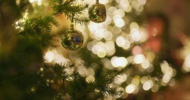 Güzel bokeh efektleri ağaçta parlayan Noel ışıklarını vurgular, neşeli atmosferi güçlendirir..