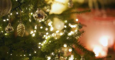 Noel ağacının üzerindeki güzel ışıklar ışıl ışıl parlıyor, dekoratif mücevherleri tamamlıyor, şenlikli bir ortamda..
