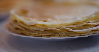 Mutfaktan taze servis edilen bir yığın sıcak, altın krep..