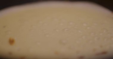 Pankekin üstünde tavada kızarırken oluşan hava kabarcıklarından oluşan bir makro yakın çekim..