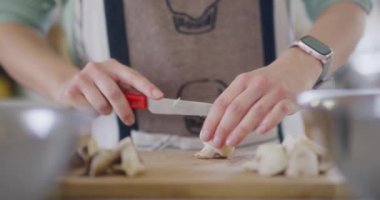 Taze mantar kesen kadın eli ve bıçağının yakın çekimi..