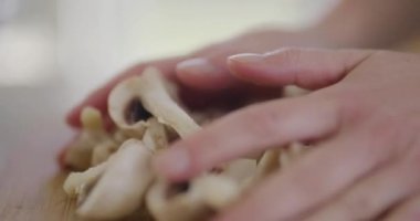 Bir şef hazırlamak için dikkatlice dilimlenmiş mantarları kaseye koyar..