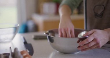 Bir kadın mutfakta özenle çalışıyor, sıfırdan ekmek hamuru hazırlıyor..