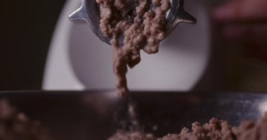 Yemek hazırlama için et öğütme sürecinin ayrıntılı bir görünümü.