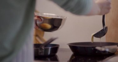 Isıtılmış tavaya dökülen krep hamuru yakın plan..