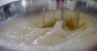 Mutfak kasesinde krep hamuru karıştıran bir mikserin yakın çekimi..