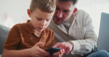 Bir baba, genç oğullarını dikkatle takip eder. Akıllı telefon tarama faaliyetleri yeniden başlar. Böylece Noel sezonunda güvenli kullanım ve sorumluluk sahibi alışkanlıklar sağlar..