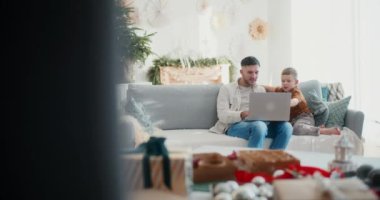 Bir baba ve küçük oğlu kanepede oturur internette sörf yapar ve bir dizüstü bilgisayardan Noel hediyesi alır. Paylaşılan şenlik heyecanı üzerine bağ kurarlar..