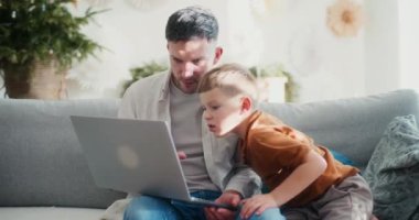 Genç bir çocuk ve babası Noel boyunca bilgisayar başında alışveriş yaparak, bayram heyecanını paylaşarak ve tatil hazırlıklarını yaparak vakit geçiriyorlar..