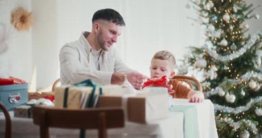 Bir baba sabırla küçük oğluna Noel hediyelerini nasıl paketleyeceğini öğretir. Yürek ısıtan bir aile anını paylaşarak birlikte güzel bayram anıları oluşturur..