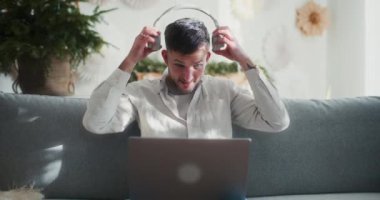 Bir adam dizüstü bilgisayarı üzerinde çalışırken kulaklık takar, sakin ve üretken bir uzak çalışma ortamında görevlerine odaklanır..