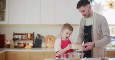 Mutlu bir çocuk fırında çalışırken babasının un ellemesine hevesle yardım eder..