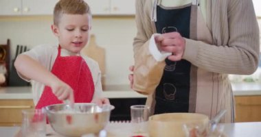 Genç bir çocuk ve babası mutfakta birlikte vakit geçirir, hamur ve ev yapımı ekmek pişirirler..