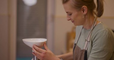 Neşeli bir kadın yemek hazırlarken mutfakta et öğütür..