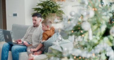 Genç bir çocuk dizüstü bilgisayarda çalışırken babasının yanına oturur. Noel sezonunda birlikte vakit geçirmekten hoşlanırlar..
