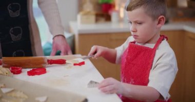 Genç bir çocuk, bayram yemeklerinde babasına yardım eder, bayram sezonunda eğlence ve öğrenme anlarını paylaşır..