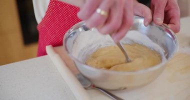 Bir baba oğluna ekmek kasesine hamur karıştırma konusunda rehberlik eder, ona mutfakta değerli pişirme becerileri öğretir..