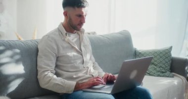 Noel 'de bir adam dizüstü bilgisayarından alışveriş yapar, hediye arar ve evdeki bayram havasının tadını çıkarır..