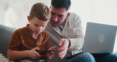 Bir baba, genç oğlunun Noel 'de güvenli ve sorumlu kullanım sağlamak için akıllı telefonunda neler aradığını dikkatle kontrol eder..