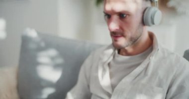 Uzaktan kumandalı, kulaklıklı, tamamen odaklanmış ve mesleki görevlerine dalmış bir adamın yakın plan görüntüsü..