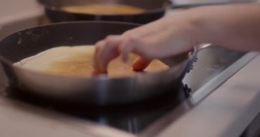 Tavada pişerken bir elin hafifçe krepe dokunması..