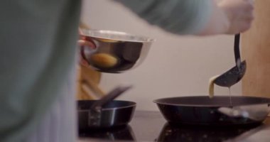 Isıtılmış tavaya dökülen krep hamuru yakın plan..