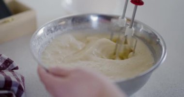 Bir mikser hamuru metal bir kasede karıştırır ve pişirmeye hazırlar..