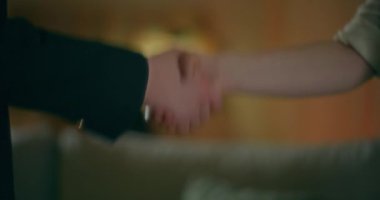 Bir emlakçı ve bir müşteri, emlak alım satımının başarıyla sonuçlanmasını kutluyor..