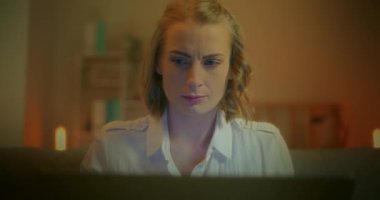 Laptop ekranına odaklanmış, gece geç saatlere kadar çalışan bir kadının yakın çekimi..