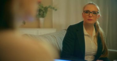 Bir işletme koçu, bir toplantı sırasında müşterilerinin sorunlarını dinler, ona zorlukların üstesinden gelmesi ve güvenle ilerlemesi için duygusal destek ve profesyonel tavsiyelerde bulunur..