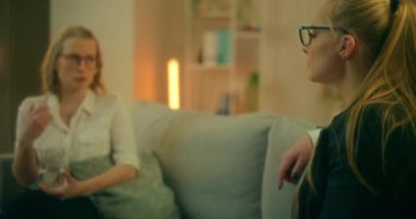 İki kadın kanepede oturup sorunlarını paylaşıyor ve ilişkilerindeki bir kriz sırasında birbirlerine duygusal destek veriyorlar..