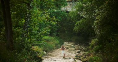 Doğal dinginlik ve sükunetle çevrili, akan bir nehirde huzur içinde meditasyon yapan bir kadının görkemli bir sahnesi..