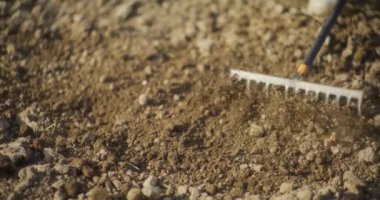 Bahçede tırmıklanan toprağın yakın plan görüntüsü ekime ve bahçeciliğe hazırlık sürecini vurguluyor..