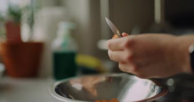 Bir kadın dikkatlice mutfağında soğan soyar, ev yapımı yemek için malzemeler hazırlar..