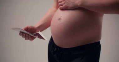 Göğsüne ultrason görüntüsü taşıyan hamile bir kadının dokunaklı görüntüsü sevgiyi ve doğmamış çocuğuyla derin bir bağı simgeliyor..