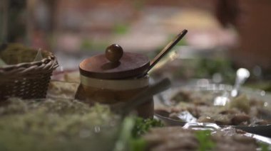 Geleneksel ahşap bir masada sunulan domuz yağı kavanozunun ve çeşitli pirzolaların yakın plan görüntüsü..